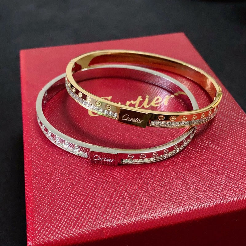 Cartier bracelets on a red box with a dark background