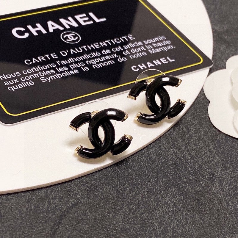 Chanel earrings on a branded card with a gray background