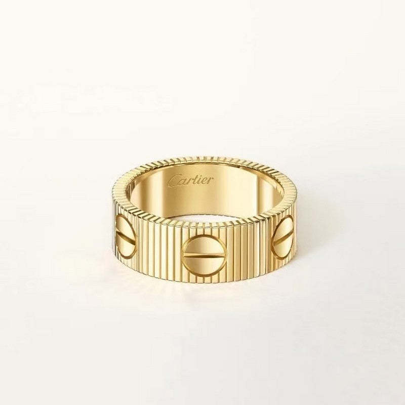 Gold ring with Cartier branding on a light beige background