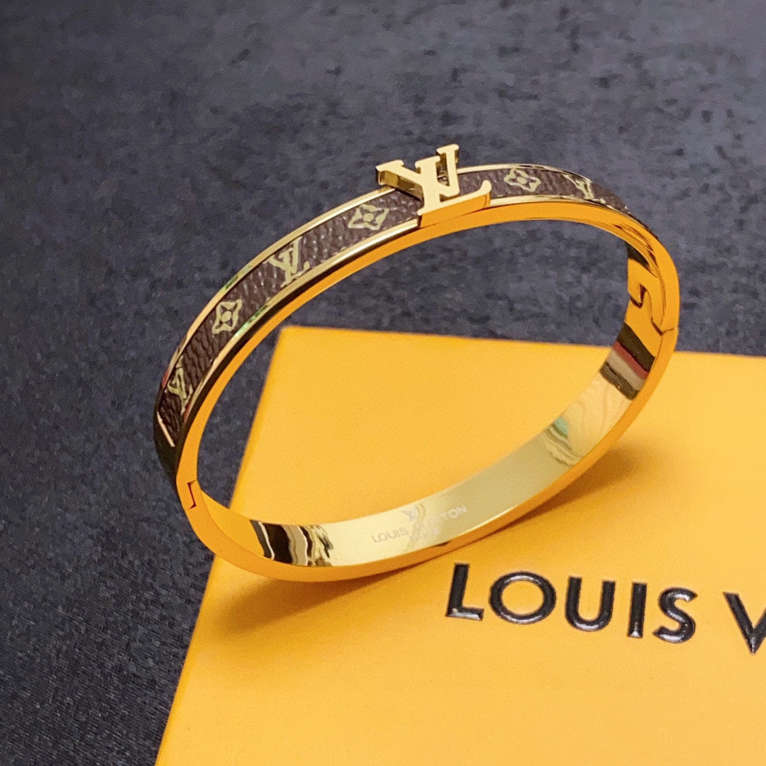 Gold bracelet with Louis Vuitton logo on a yellow box