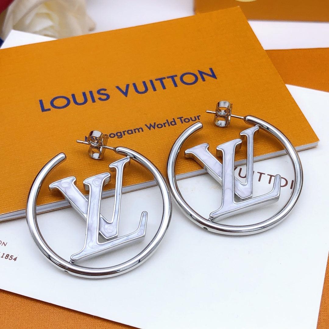 Silver earrings with 'LV' logo on a Louis Vuitton background
