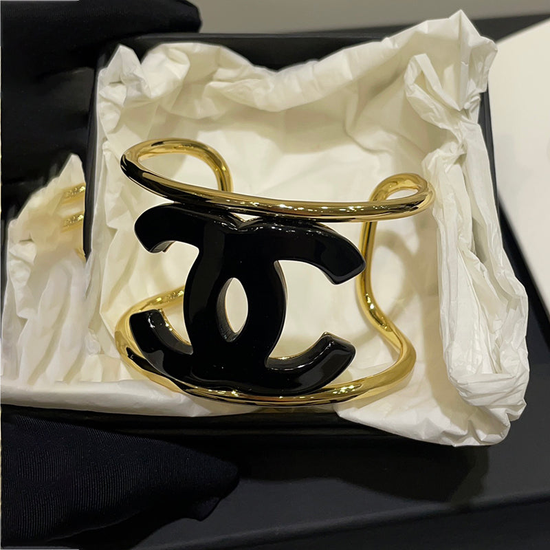 Gold and black Chanel bracelet in a white box