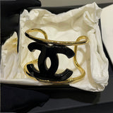 Gold and black Chanel bracelet in a white box