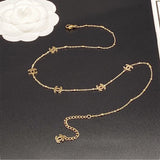 Gold chain belt withCC logo on a black surface