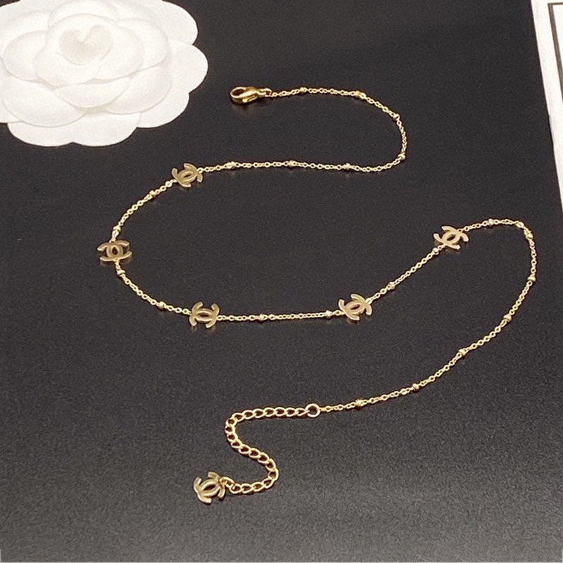 Gold chain belt withCC logo on a black surface